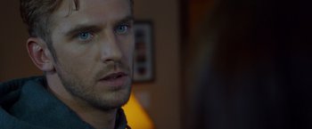 Movie still from “The Guest” (2014), directed by Adam Wingard – A man's face in the dark; Close Up shot, Over the shoulder angle