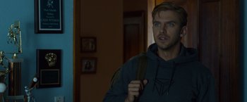 Movie still from “The Guest” (2014), directed by Adam Wingard – A man with a backpack in a dark room; Close Up shot, Over the shoulder angle
