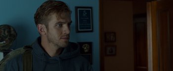 Movie still from “The Guest” (2014), directed by Adam Wingard – A man in a gray hoodie is looking to his left; Close Up shot, Over the shoulder angle