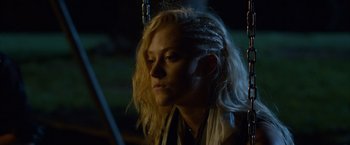 Movie still from “The Guest” (2014), directed by Adam Wingard – A woman with long blonde hair sitting in a dark room; Close Up shot, Over the shoulder angle