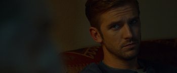 Movie still from “The Guest” (2014), directed by Adam Wingard – A person's face in a dark room; Close Up shot, Over the shoulder angle