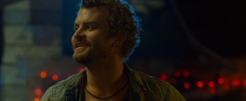 Movie still from “The Guest” (2014), directed by Adam Wingard – A person with curly hair and a beard; Close Up shot, Over the shoulder angle