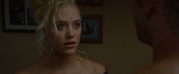 Movie still from “The Guest” (2014), directed by Adam Wingard – A beautiful young blonde woman in front of a picture; Close Up shot, Over the shoulder angle