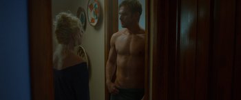 Movie still from “The Guest” (2014), directed by Adam Wingard – A man standing in front of a mirror next to a woman; Medium shot, Over the shoulder angle