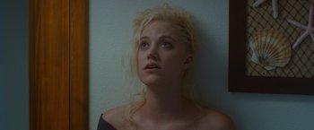 Movie still from “The Guest” (2014), directed by Adam Wingard – A woman with blonde curly hair looking upward; Close Up shot, Low angle