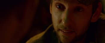 Movie still from “The Guest” (2014), directed by Adam Wingard – A man's face in a dimly - lit room; Extreme Close Up shot, Over the shoulder angle