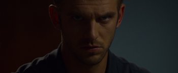 Movie still from “The Guest” (2014), directed by Adam Wingard – A man's face in a dark room; Close Up shot, Over the shoulder angle