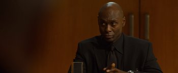 Movie still from “The Guest” (2014), directed by Adam Wingard – A man in a black suit and a black tie; Close Up shot, Over the shoulder angle