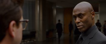 Movie still from “The Guest” (2014), directed by Adam Wingard – A man with a bald head standing in a hallway; Close Up shot, Over the shoulder angle