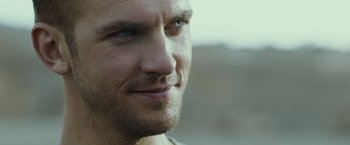 Movie still from “The Guest” (2014), directed by Adam Wingard – A man's face with a blurry background; Close Up shot, Over the shoulder angle