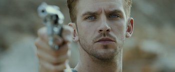 Movie still from “The Guest” (2014), directed by Adam Wingard – A person holding a gun; Close Up shot, Over the shoulder angle