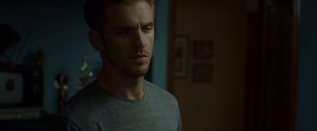 Movie still from “The Guest” (2014), directed by Adam Wingard – A person wearing a gray t - shirt; Close Up shot, Over the shoulder angle