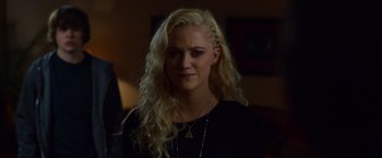 Movie still from “The Guest” (2014), directed by Adam Wingard – A woman with long blonde hair wearing a black shirt; Close Up shot, Over the shoulder angle