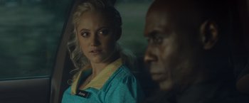 Movie still from “The Guest” (2014), directed by Adam Wingard – A woman and a black man in a car; Close Up shot, Over the shoulder angle