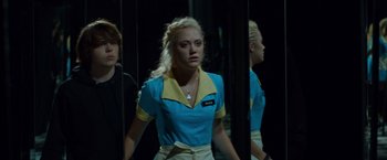 Movie still from “The Guest” (2014), directed by Adam Wingard – A woman standing in front of two other women; Medium shot, Over the shoulder angle
