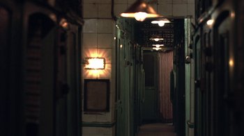 Movie still from “The Hand” (2004), directed by Kar-Wai Wong – A long hallway with a light on the wall; Wide shot, High angle