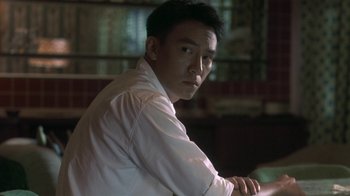 Movie still from “The Hand” (2004), directed by Kar-Wai Wong – A man in a white shirt is sitting in front of a window; Close Up shot, Low angle