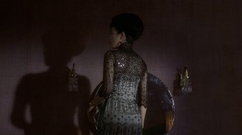 Movie still from “The Hand” (2004), directed by Kar-Wai Wong – A woman standing in front of a mirror in a room; Medium shot, High angle