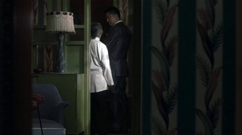Movie still from “The Hand” (2004), directed by Kar-Wai Wong – A man and a woman standing next to each other in a room; Wide shot, Over the shoulder angle