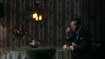 Movie still from “The Hand” (2004), directed by Kar-Wai Wong – A man sitting at a dinner table talking on a cell phone; Medium shot, High angle