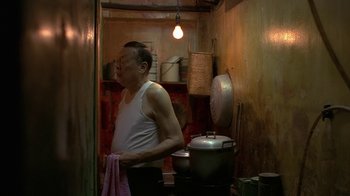 Movie still from “The Hand” (2004), directed by Kar-Wai Wong – A man standing in front of a pot in a kitchen; Medium shot, Low angle
