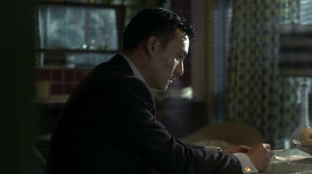 Movie still from “The Hand” (2004), directed by Kar-Wai Wong – A man sitting at a table looking at a computer screen; Close Up shot, Low angle