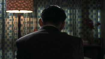 Movie still from “The Hand” (2004), directed by Kar-Wai Wong – The back of a man's head in a suit; Close Up shot, Over the shoulder angle