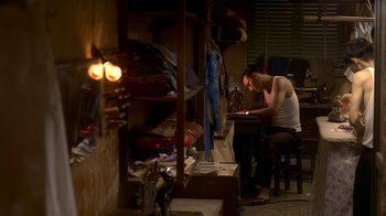 Movie still from “The Hand” (2004), directed by Kar-Wai Wong – A man sitting at a table using a laptop; Wide shot, High angle