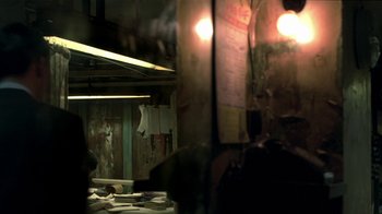 Movie still from “The Hand” (2004), directed by Kar-Wai Wong – A dark room with a lot of lights on the wall; Medium shot, Over the shoulder angle