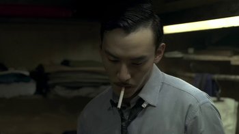 Movie still from “The Hand” (2004), directed by Kar-Wai Wong – A man in a tie is smoking a cigarette; Close Up shot, Over the shoulder angle
