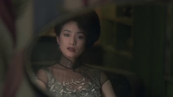 A woman in a dress is looking out a window