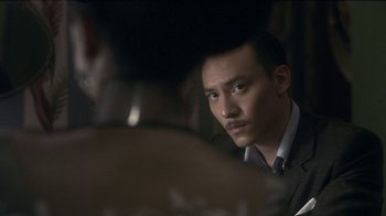 Movie still from “The Hand” (2004), directed by Kar-Wai Wong – A man in a suit looking at himself in the mirror; Close Up shot, Over the shoulder angle