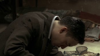 Movie still from “The Hand” (2004), directed by Kar-Wai Wong – A man in a brown jacket is bowing his head down; Close Up shot, High angle
