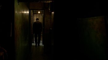 Movie still from “The Hand” (2004), directed by Kar-Wai Wong – A man is walking through a dark hallway; Wide shot, Low angle