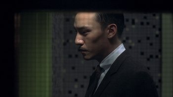 Movie still from “The Hand” (2004), directed by Kar-Wai Wong – A man wearing a suit and tie standing next to a wall; Close Up shot, Low angle