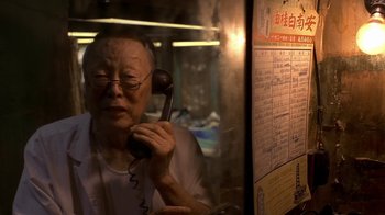Movie still from “The Hand” (2004), directed by Kar-Wai Wong – An older man holding a phone up to his ear; Close Up shot, High angle