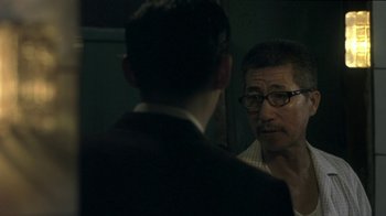 Movie still from “The Hand” (2004), directed by Kar-Wai Wong – A man with glasses is looking at a man in a suit; Close Up shot, Over the shoulder angle
