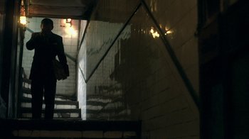 Movie still from “The Hand” (2004), directed by Kar-Wai Wong – A person walking up a flight of stairs in the dark; Wide shot, Low angle