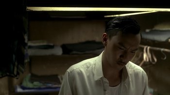Movie still from “The Hand” (2004), directed by Kar-Wai Wong – A man in a white shirt is looking down; Close Up shot, Low angle