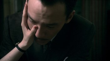 Movie still from “The Hand” (2004), directed by Kar-Wai Wong – A person wearing a suit and tie; Close Up shot, High angle