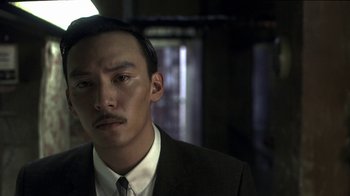 Movie still from “The Hand” (2004), directed by Kar-Wai Wong – A person wearing a suit and tie; Close Up shot, Low angle