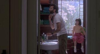 Movie still from “The Hand That Rocks the Cradle” (1992), directed by Curtis Hanson – A man standing in front of a bathroom sink brushing his teeth; Medium shot, Over the shoulder angle