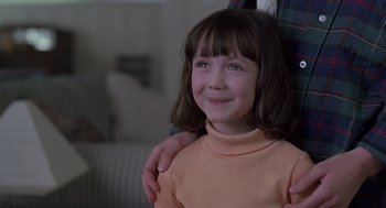 Movie still from “The Hand That Rocks the Cradle” (1992), directed by Curtis Hanson – A little girl with her arms around a person; Close Up shot, Over the shoulder angle