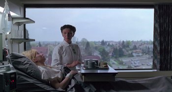 Movie still from “The Hand That Rocks the Cradle” (1992), directed by Curtis Hanson – Two women sitting in front of a large window; Medium shot, Low angle