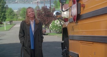 A woman standing in front of a school bus