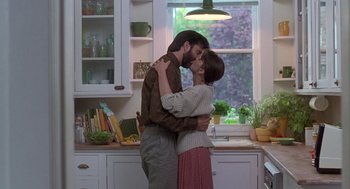 Movie still from “The Hand That Rocks the Cradle” (1992), directed by Curtis Hanson – A man and a woman kissing in a kitchen; Medium shot, Low angle