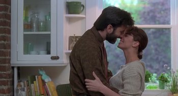 Movie still from “The Hand That Rocks the Cradle” (1992), directed by Curtis Hanson – A man and a woman are kissing in a room; Medium shot, Over the shoulder angle