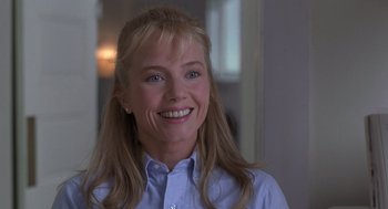Movie still from “The Hand That Rocks the Cradle” (1992), directed by Curtis Hanson – A woman with long blonde hair wearing a blue shirt; Close Up shot, Over the shoulder angle
