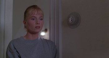 Movie still from “The Hand That Rocks the Cradle” (1992), directed by Curtis Hanson – A woman standing in front of a fire alarm; Close Up shot, Low angle