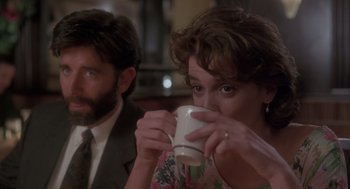 Movie still from “The Hand That Rocks the Cradle” (1992), directed by Curtis Hanson – A man and a woman sitting at a table drinking coffee; Close Up shot, Over the shoulder angle